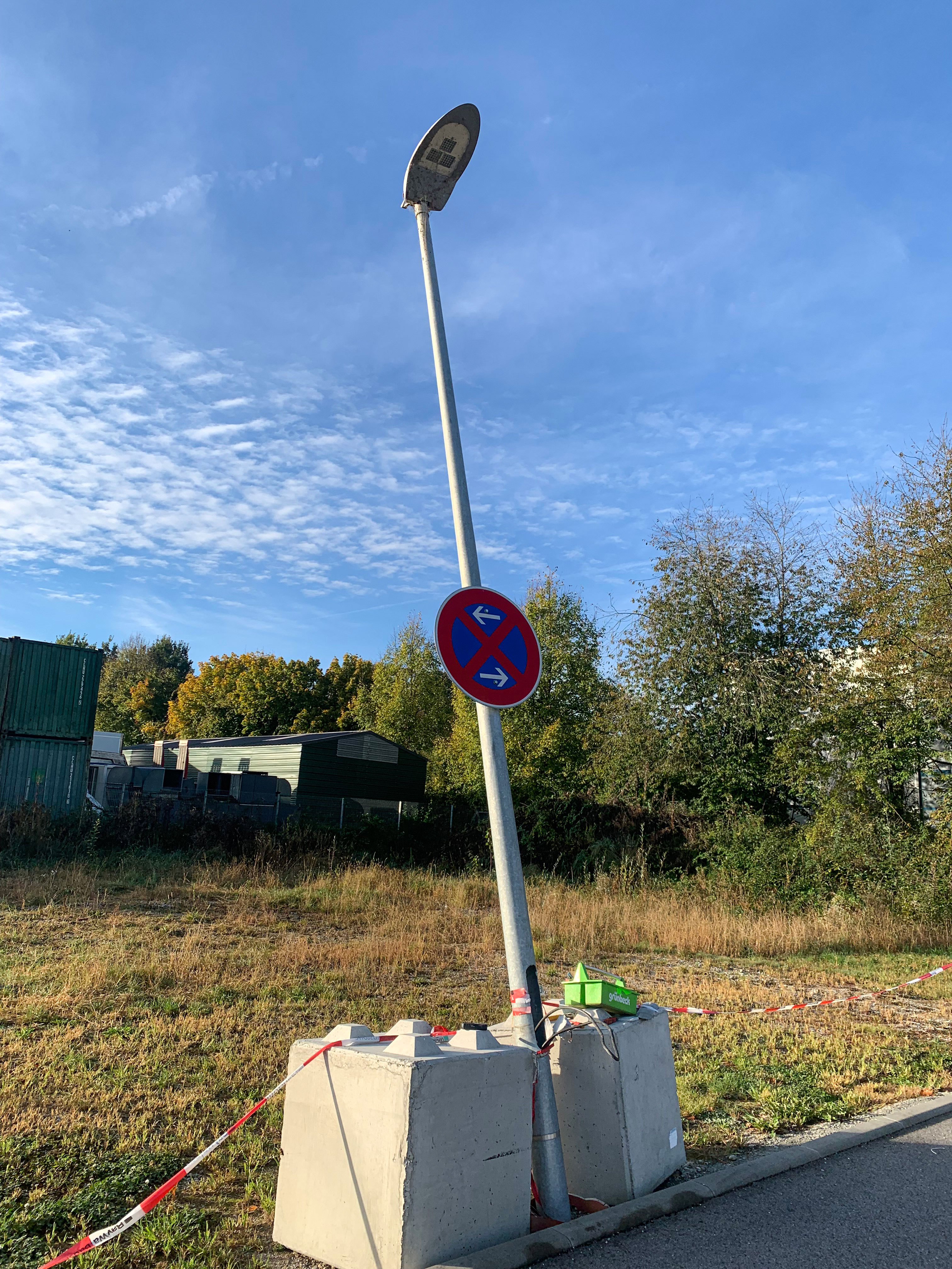 Der Lichtmast droht umzukippen. Glücklicherweise nicht in der Richtung wo die Autos parken oder wo die Fußgänger laufen.